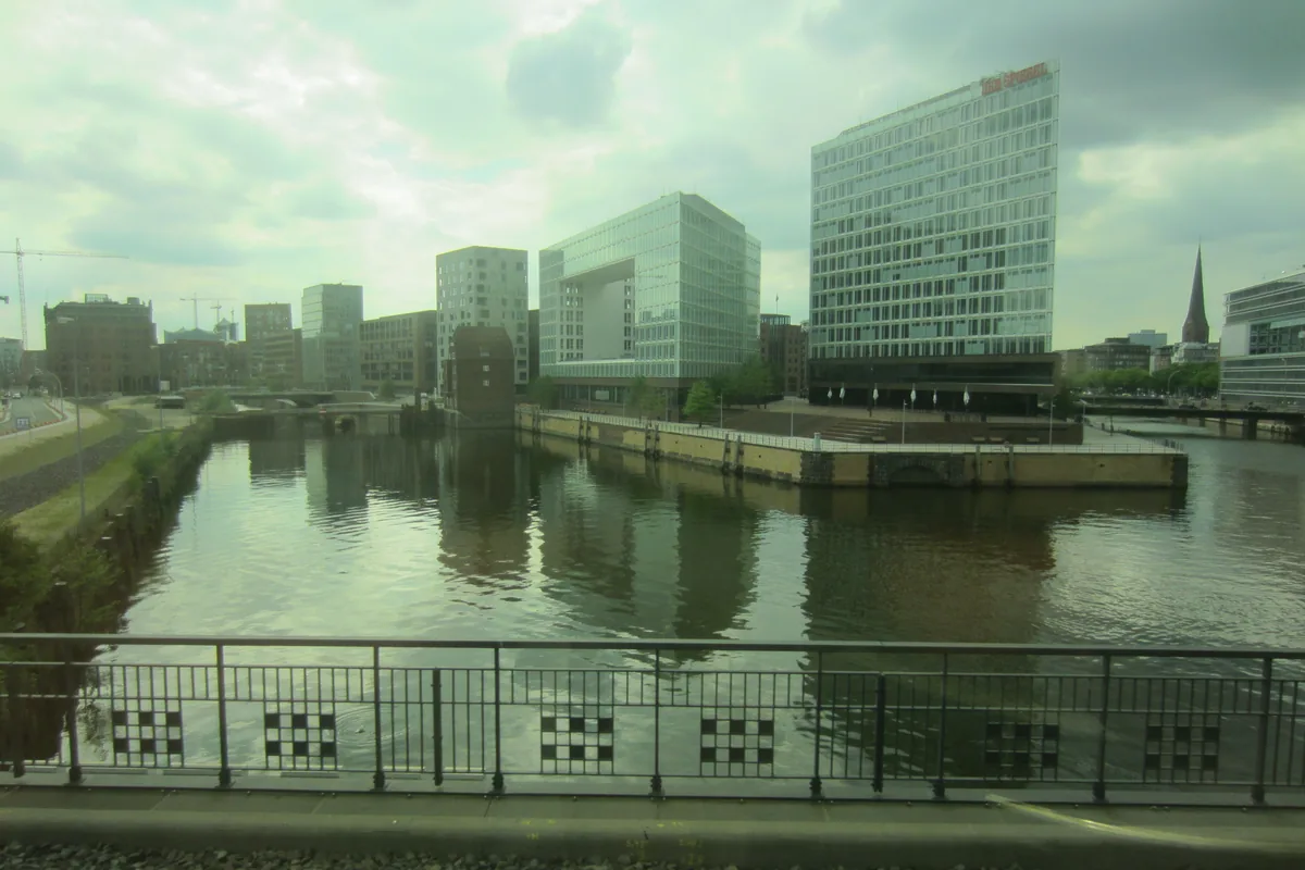Blick aus der Bahn auf Wasser und moderne Gebäude in Hamburg