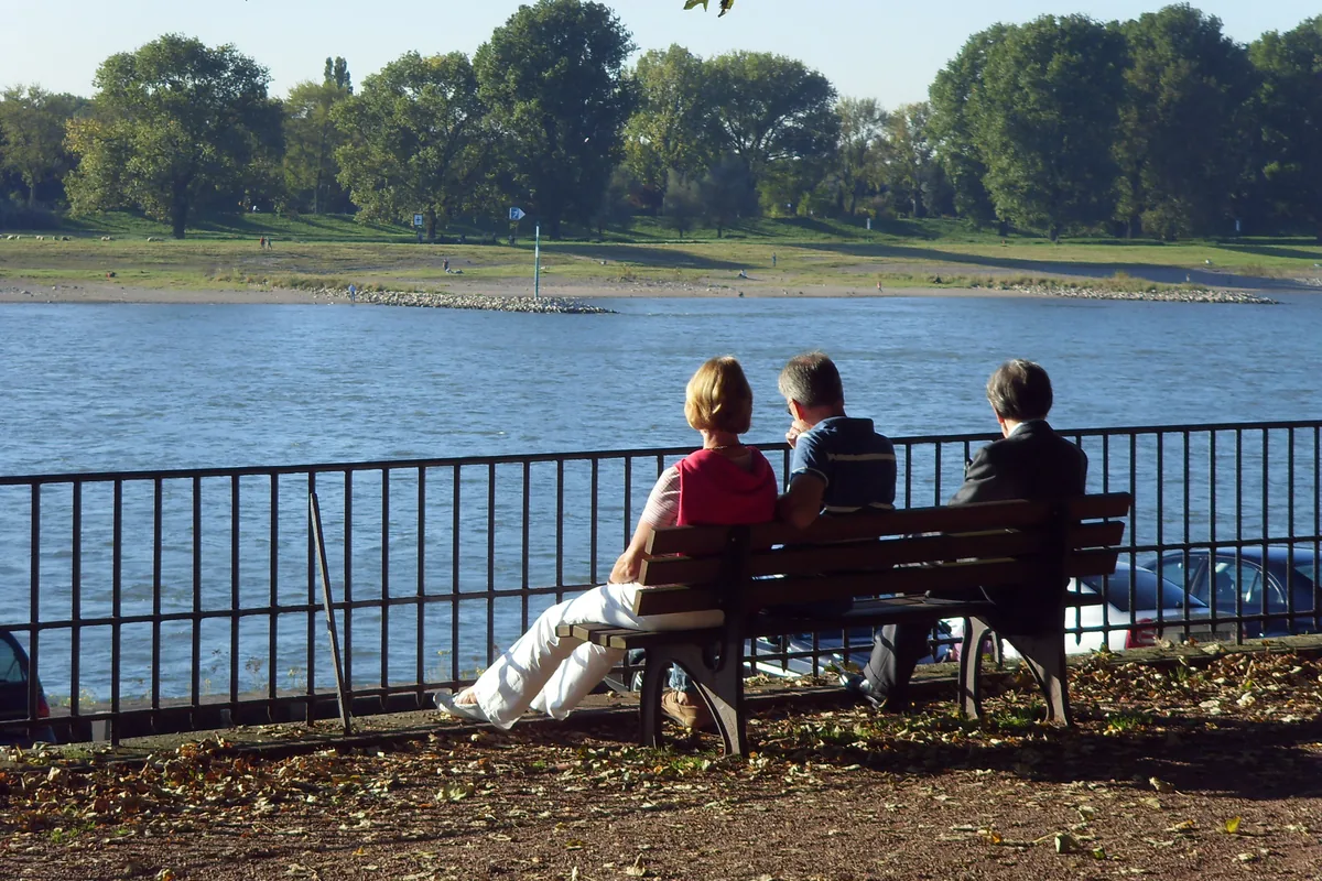 Menschen an einem Flussufer in einer Stadt